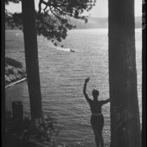 Woman waving at motorboat, Lake Arrowhead, 1929