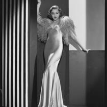 Actress Kathleen Burke modeling an evening gown with ostrich wrap, 1932