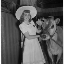 Donna Larson and Elsie the Borden Cow, star of the 1940 film "Little Men," Los Angeles, 1940